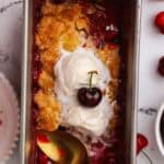 small batch cherry cobbler in a loaf pan topped with ice cream