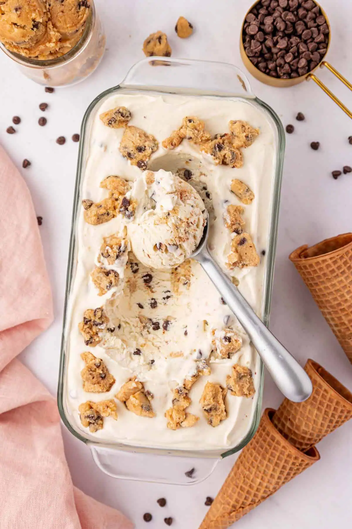 loaf pan of cookie dough ice cream with a cookie scoop in it