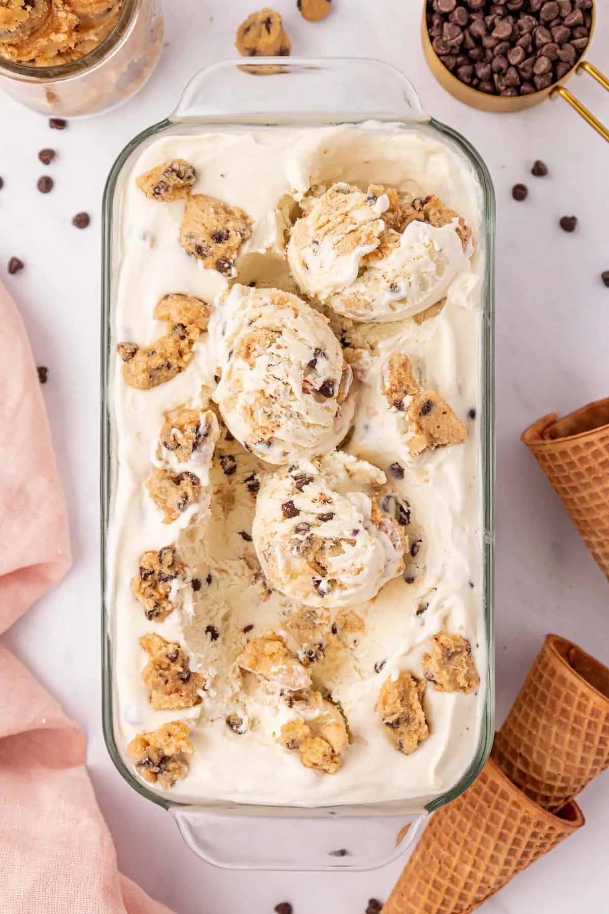 loaf pan of cookie dough ice cream with three scoops scooped on top