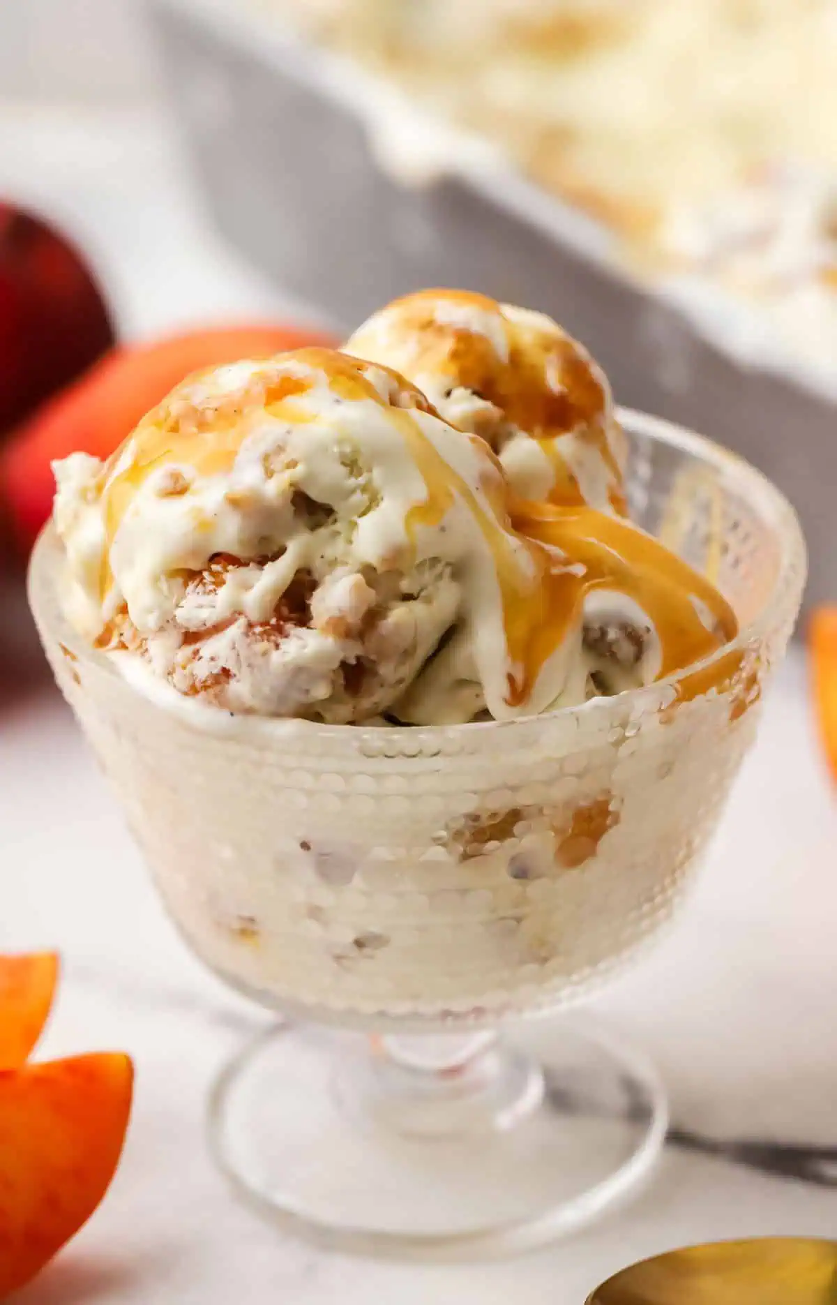 peach cobbler ice cream in a bowl topped with caramel