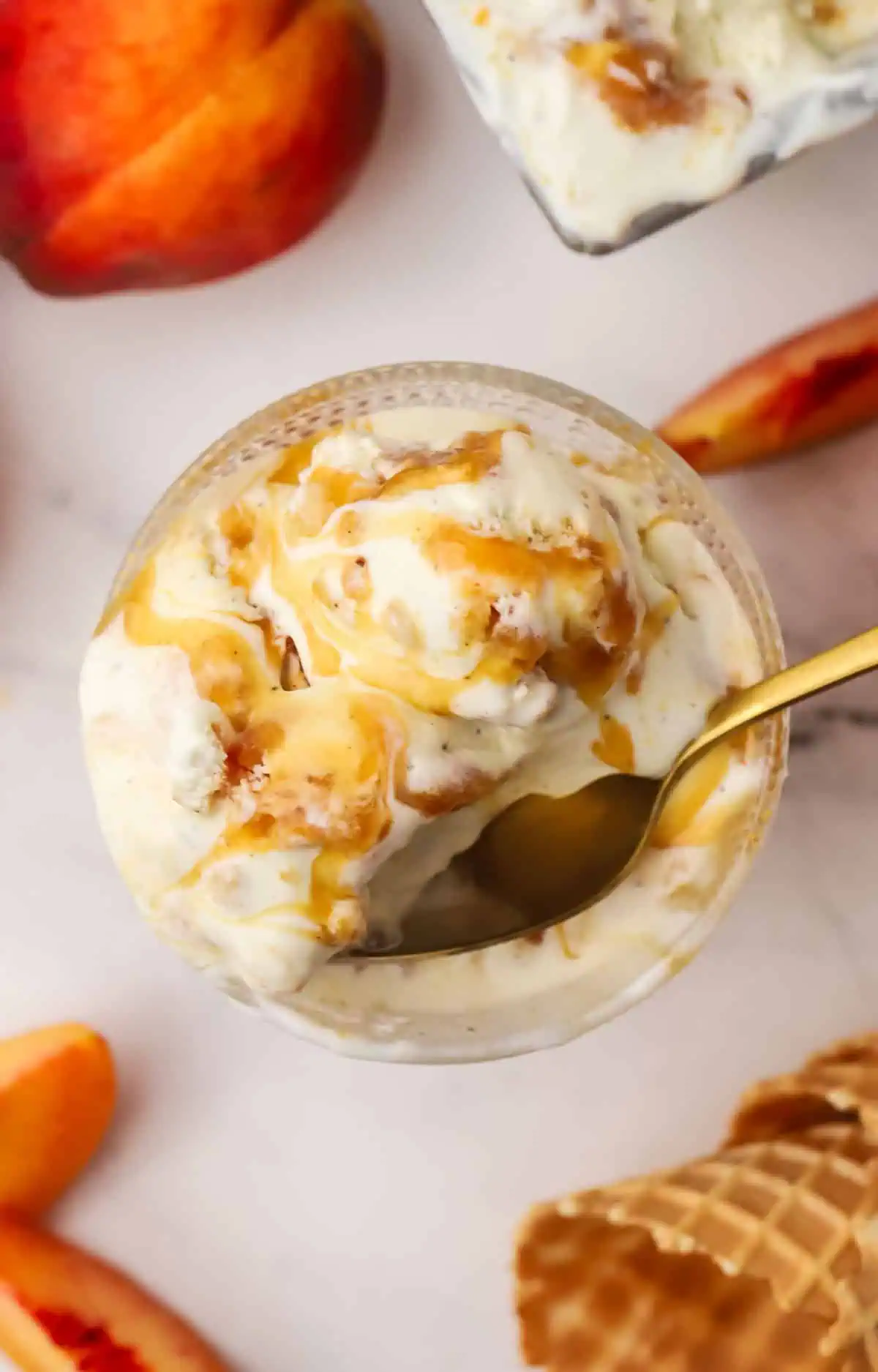 spoon in a dish with peach cobbler ice cream in it