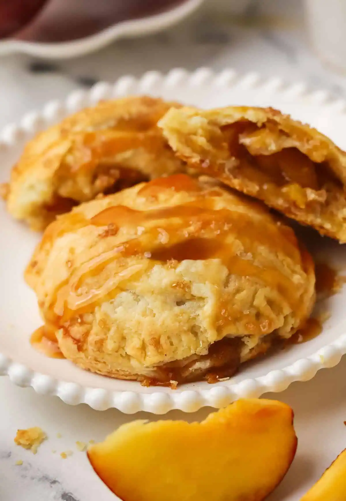 peach hand pie on a plate topped with caramel sauce
