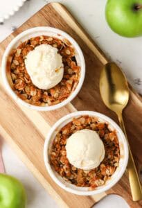 two ramekins of apple crisp topped with apple crisp