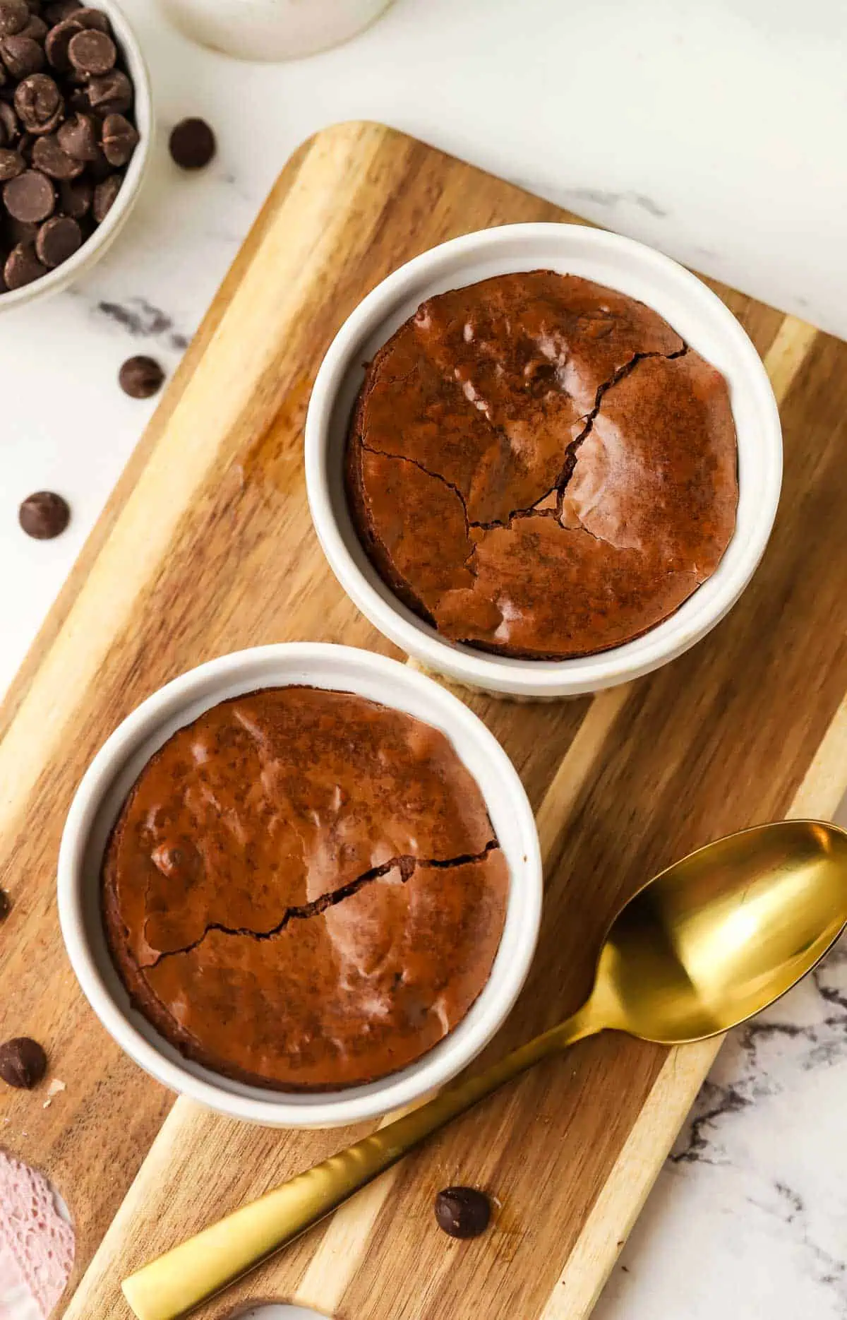 two brownie ramekins on a cutting board