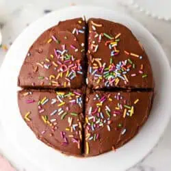 mini chocolate cake on a cake stand cut into four servings