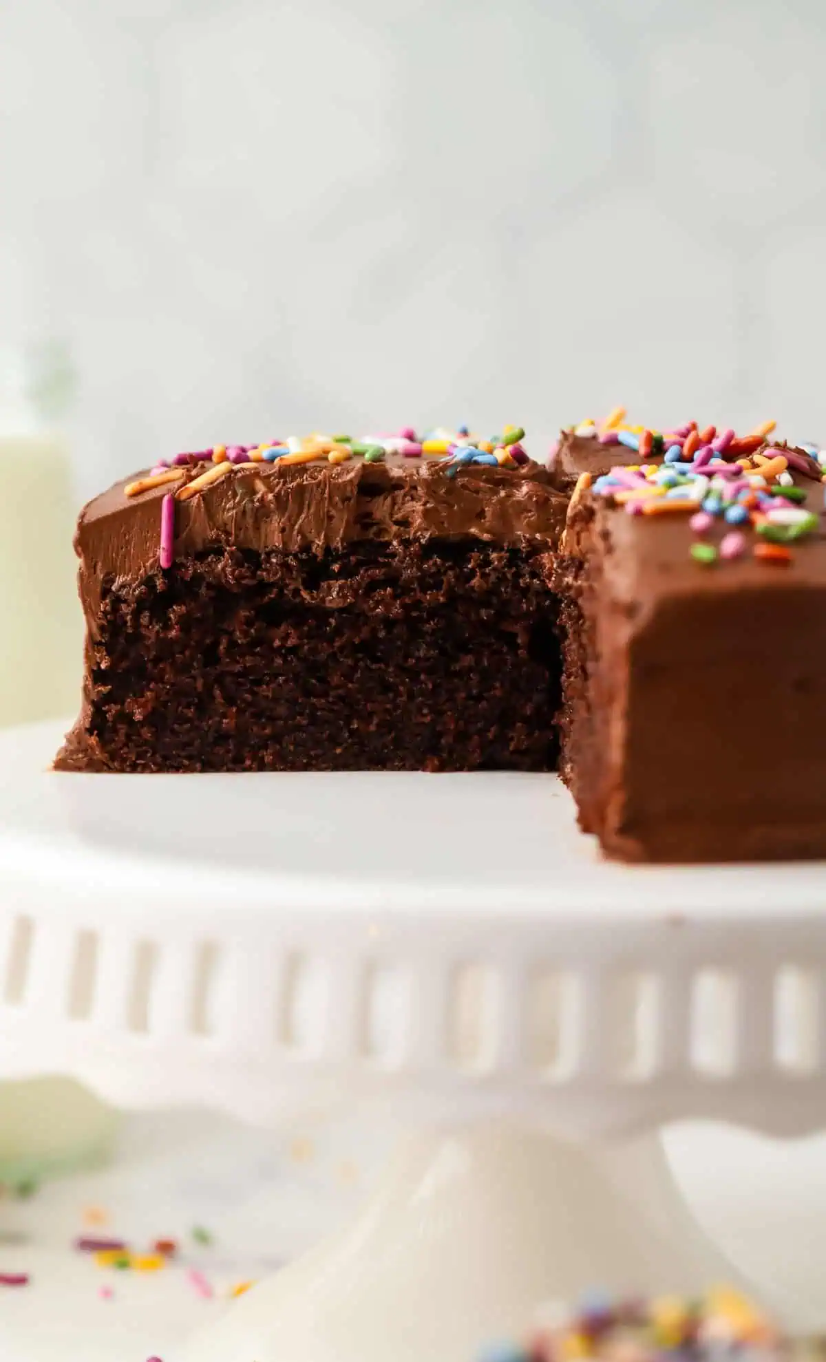 mini chocolate cake on a cake stand with a slice missing