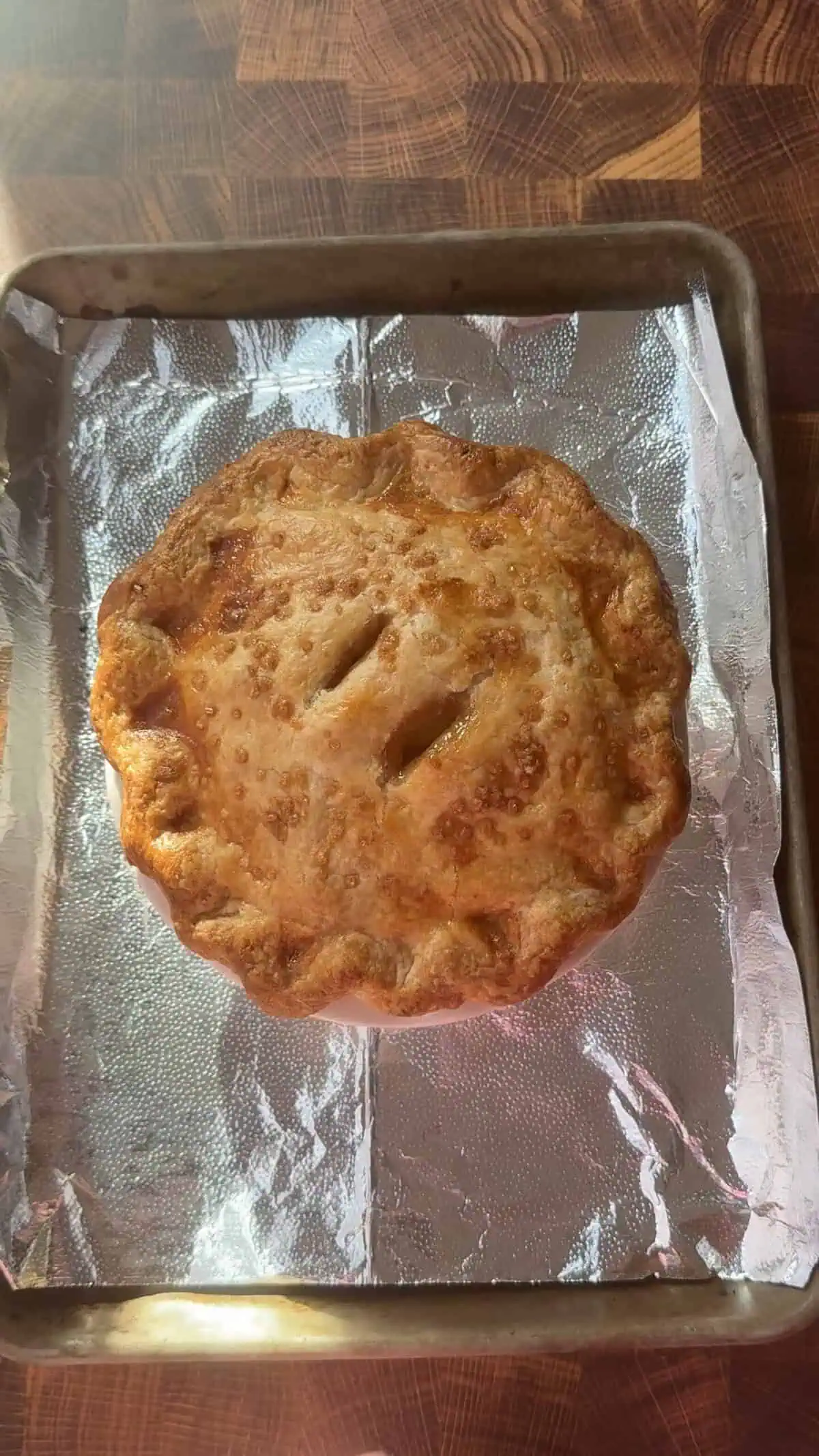 small apple pie baked on a cookie sheet