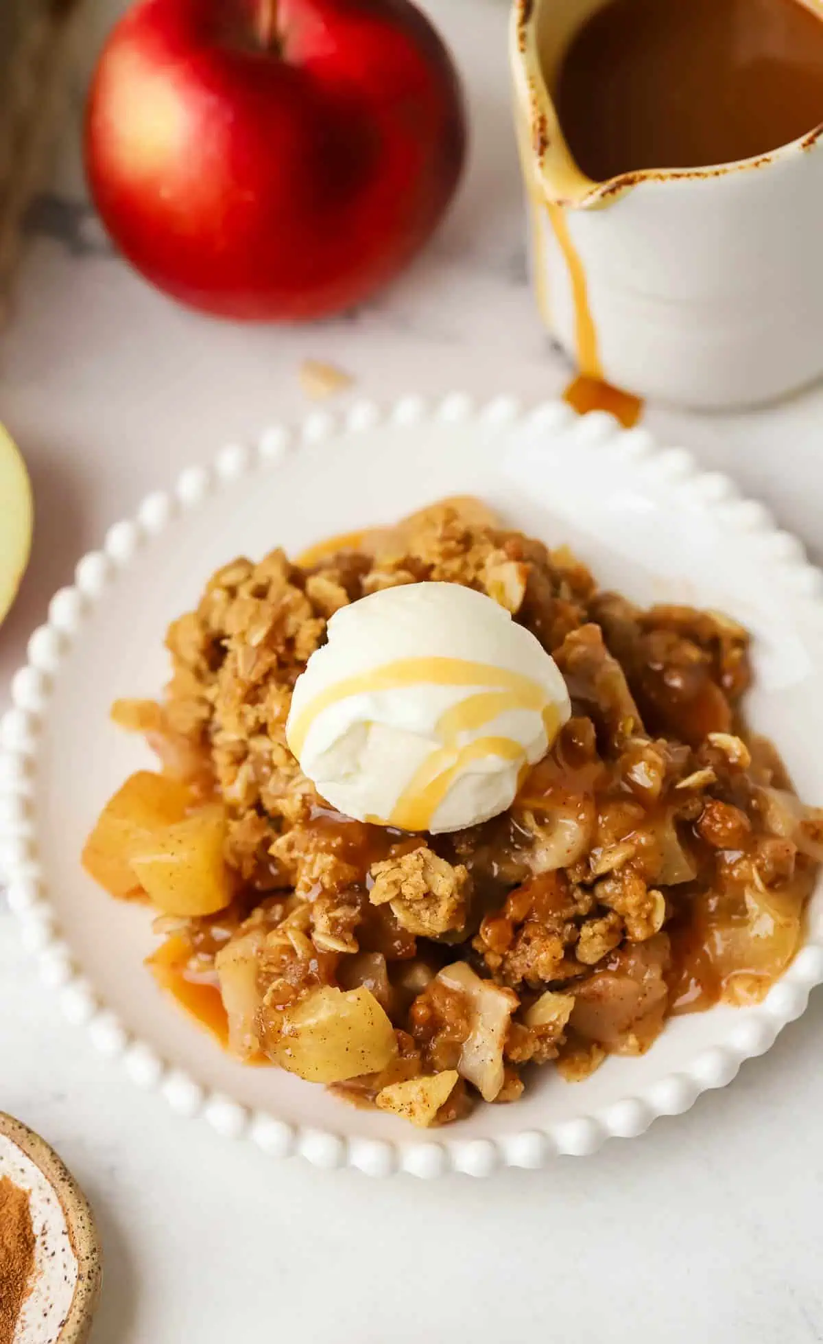 plate of apple crisp topped with caramel and ice cream