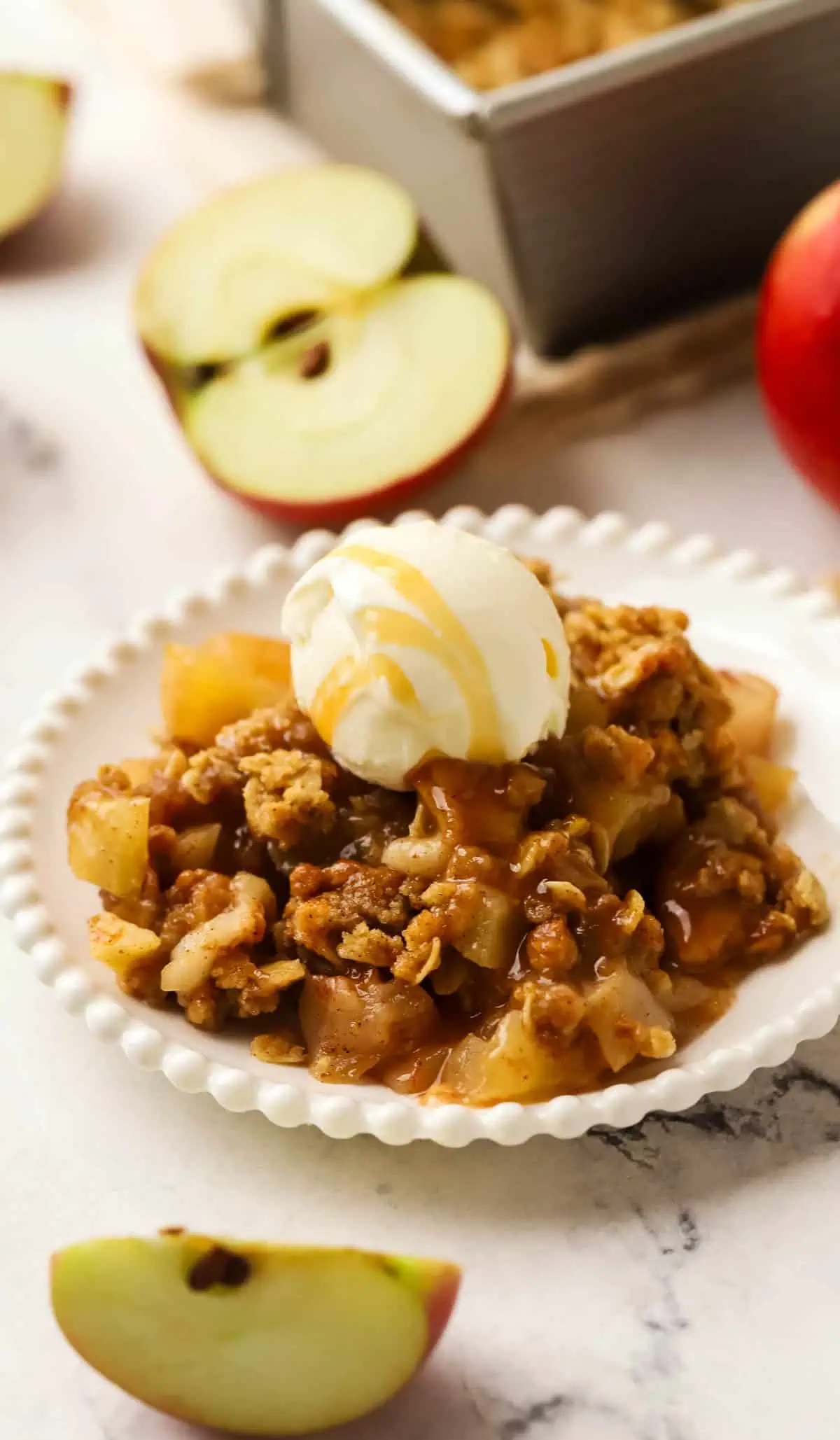 plate of apple crisp with caramel poured over it