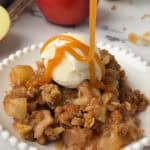 plate of apple crisp topped with caramel and ice cream