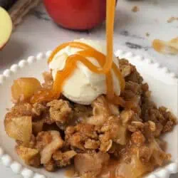 plate of apple crisp topped with caramel and ice cream