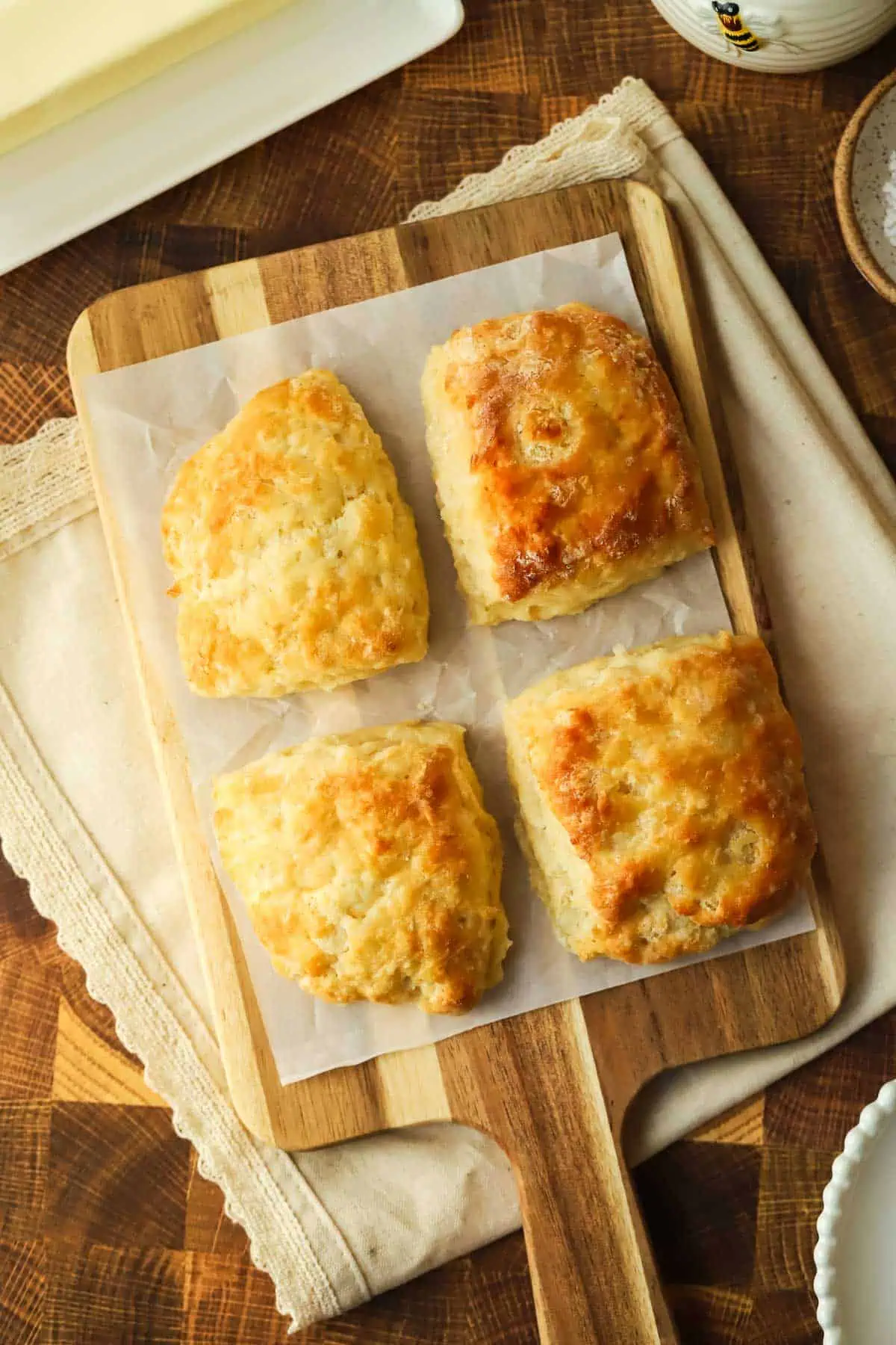 four baked biscuits on a cutting board