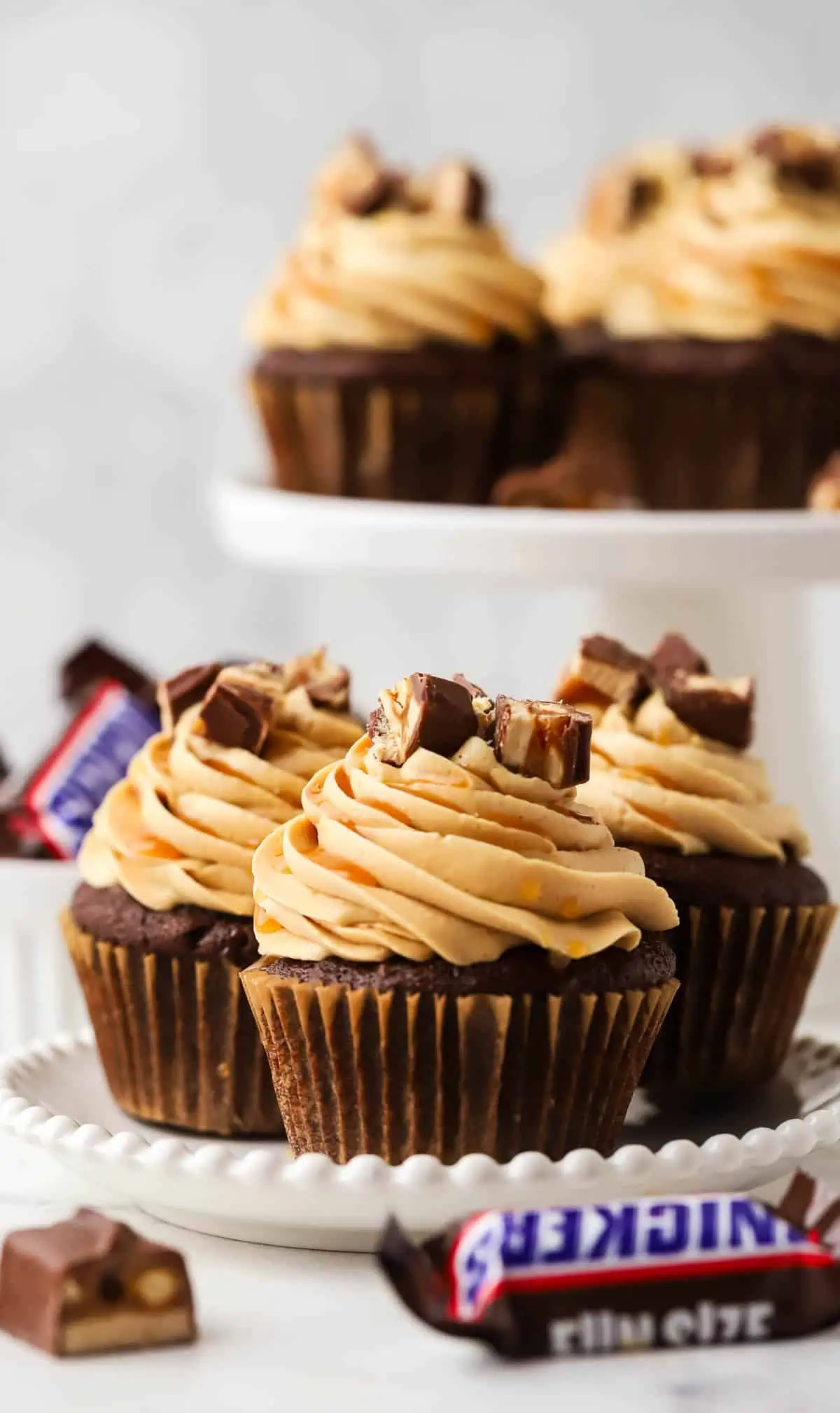 three Snickers cupcakes on a plate